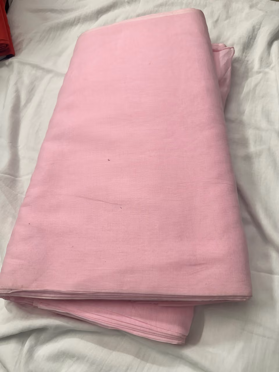 Folded pink turban fabric displayed by Divneet Singh Turban Center